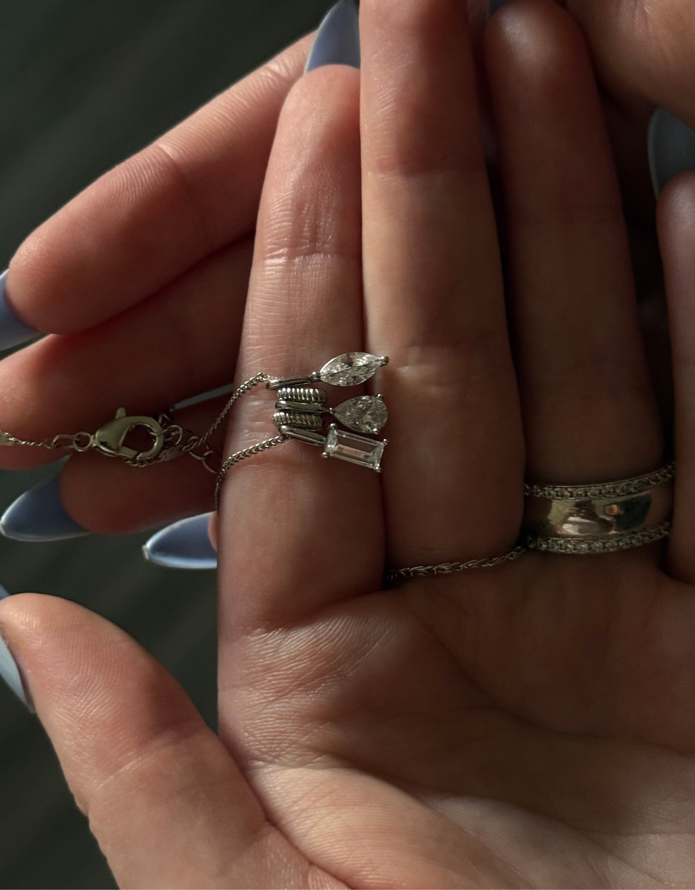 Close-up of a hand wearing multiple rings with a blurred background