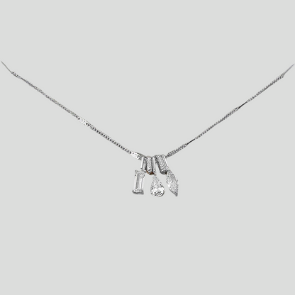 Silver necklace with three charms on a light gray background
