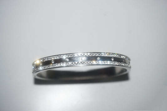 Silver ring with embedded diamonds on a light gray background